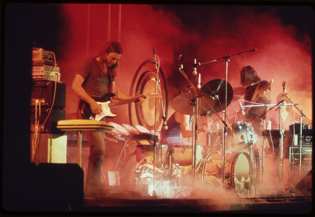 Pink Floyds David Gilmour and Roger Waters flank drummer Nick Mason on stage.